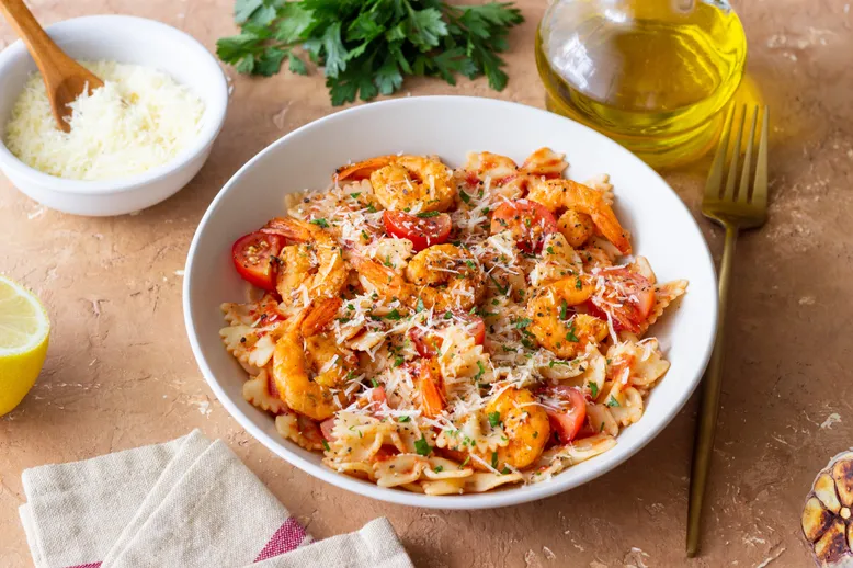 Farfalle pasta with shrimps, tomatoes and cheese. Healthy